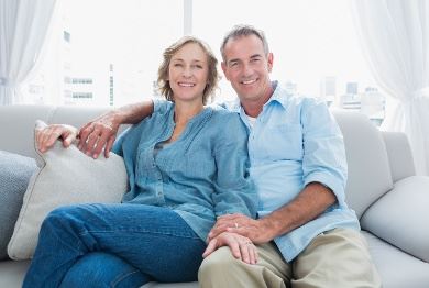 Older couple sitting on the couch smiling