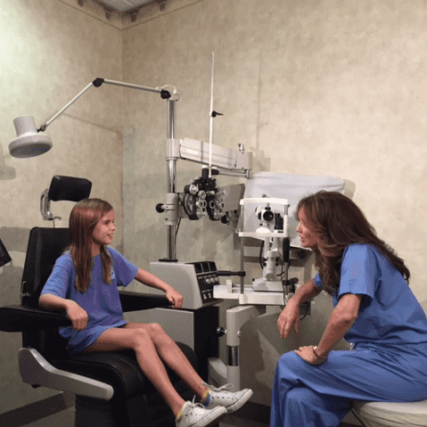 Dr. Hoelscher talking to a young girl in the examination room