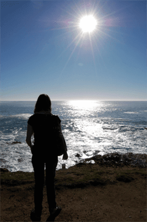 Woman looking into the ocean on the beach