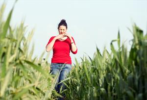 Woman walking in grass looking uncomfortable 